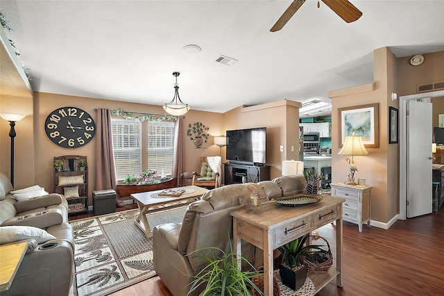 living room with ceiling fan and dark wood-type flooring