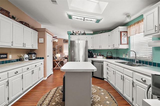 kitchen featuring white cabinetry, sink, a kitchen island, and appliances with stainless steel finishes