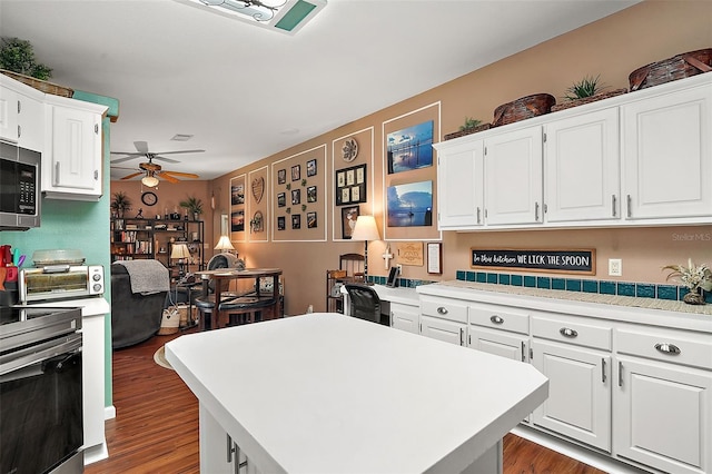 kitchen with a center island, white cabinets, ceiling fan, dark hardwood / wood-style floors, and range