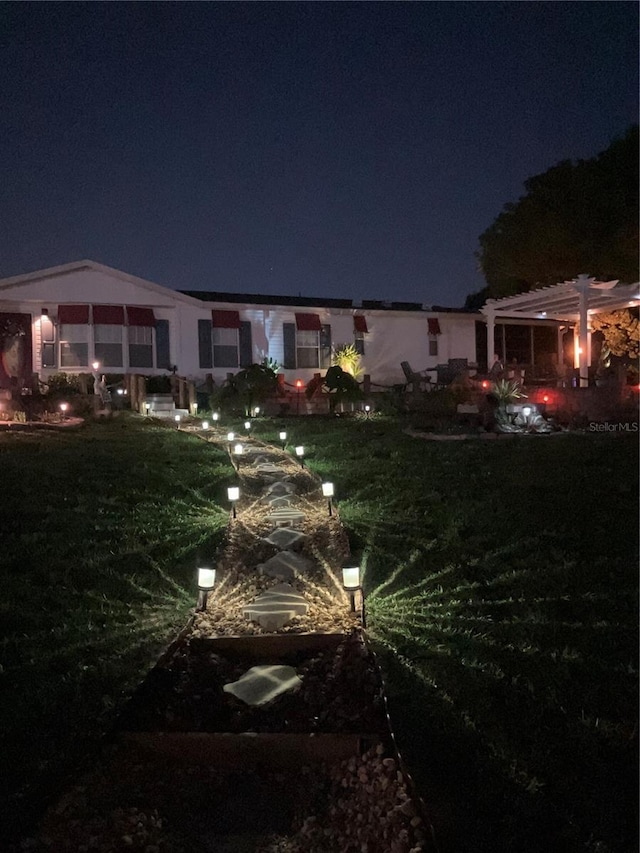 back house at night with a pergola