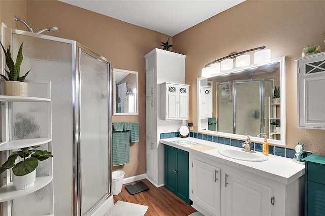 bathroom with hardwood / wood-style floors, vanity, and walk in shower