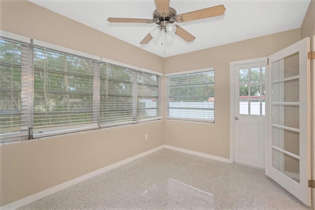 unfurnished sunroom with ceiling fan