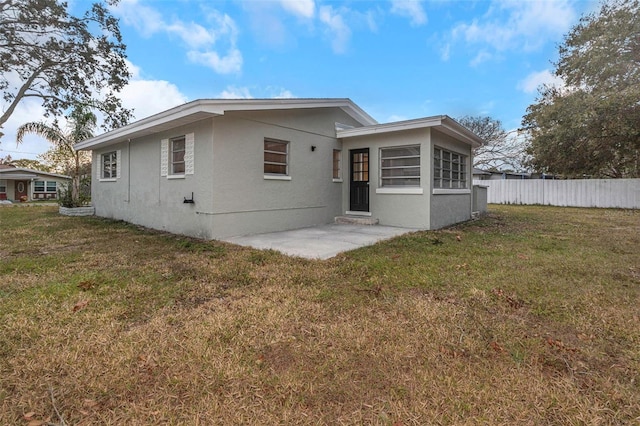 rear view of house with a yard and a patio area