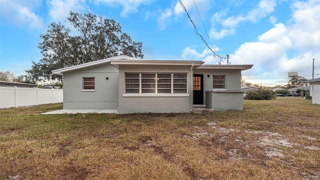 back of property with a lawn