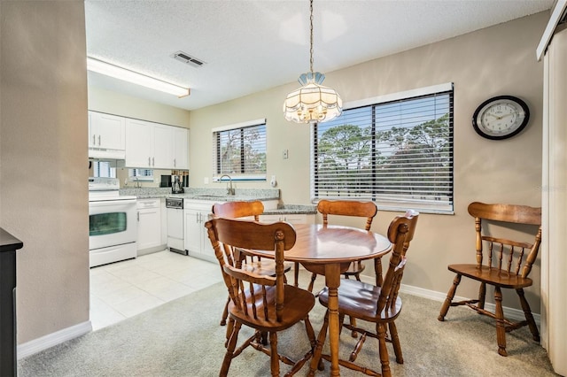 dining space with a textured ceiling, light colored carpet, sink, and an inviting chandelier