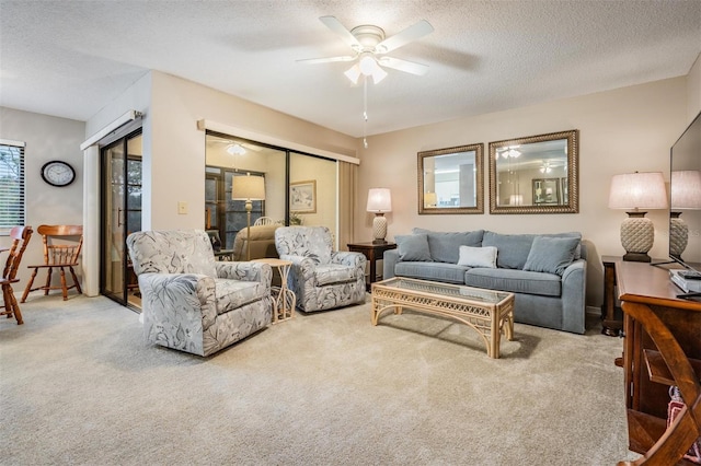 living room featuring a textured ceiling, light colored carpet, and ceiling fan