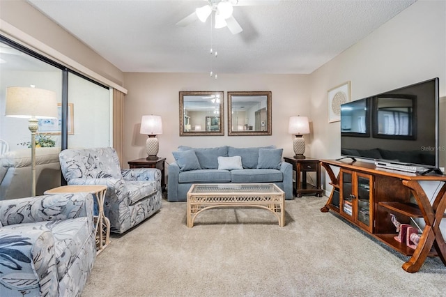 living room featuring light carpet, ceiling fan, and a textured ceiling