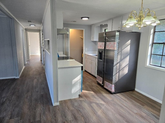 kitchen with white cabinetry, wall chimney exhaust hood, stainless steel refrigerator with ice dispenser, and an inviting chandelier