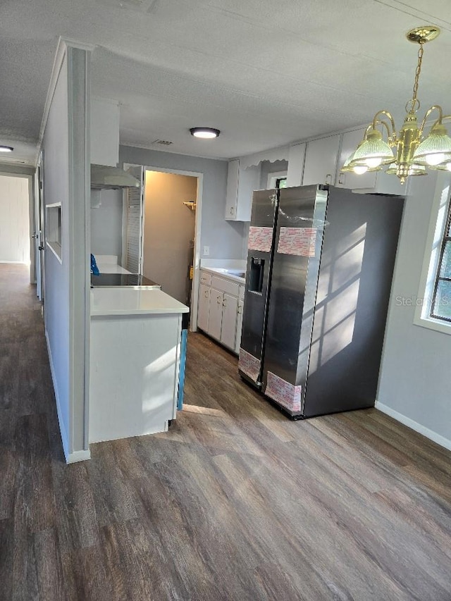 kitchen with dark wood-type flooring, a textured ceiling, decorative light fixtures, white cabinetry, and fridge with ice dispenser