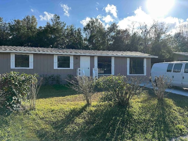 single story home featuring a front lawn