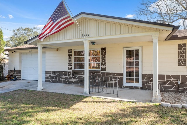 view of front of property featuring covered porch, driveway, a front lawn, and an attached garage