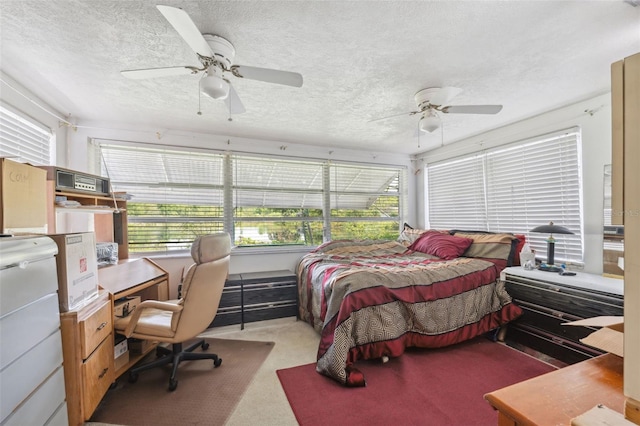bedroom with a ceiling fan, carpet flooring, and a textured ceiling