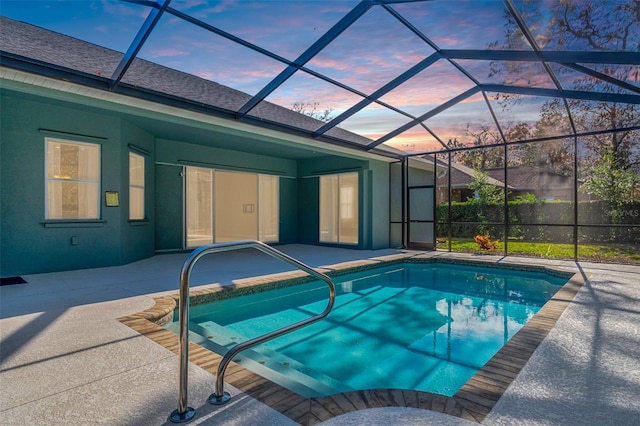 pool at dusk with a patio and glass enclosure