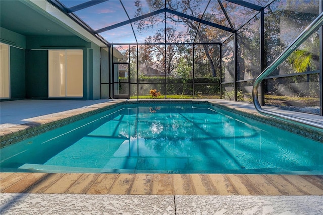 pool at dusk featuring a patio and glass enclosure