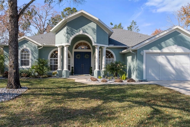 view of front of home with a front yard and a garage