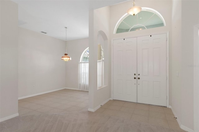 tiled entryway with a towering ceiling