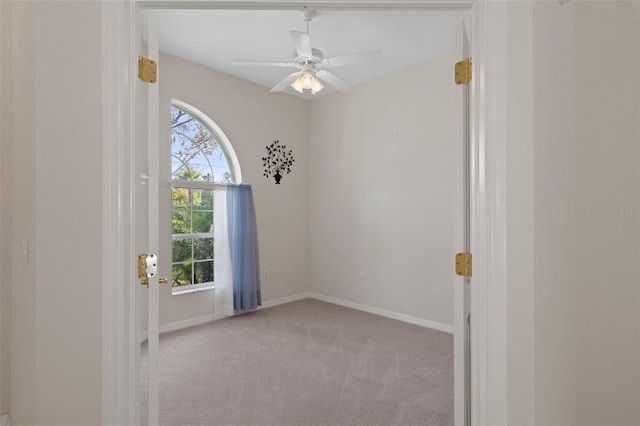 carpeted spare room featuring ceiling fan