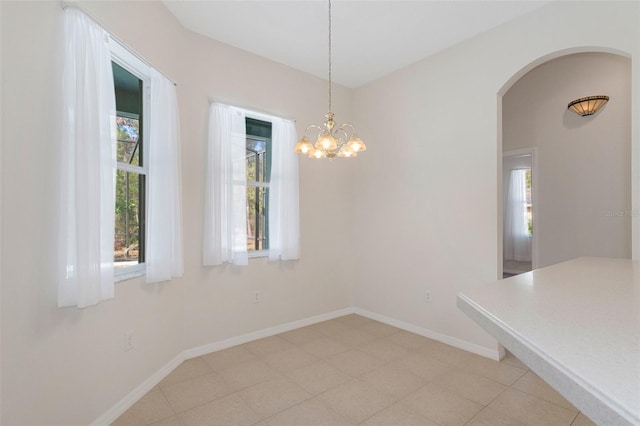 unfurnished dining area with an inviting chandelier