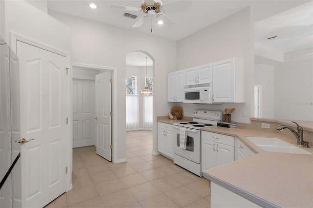 kitchen with white appliances, ceiling fan, white cabinetry, and sink