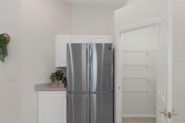 kitchen with stainless steel refrigerator and white cabinetry