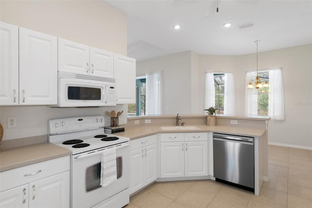 kitchen featuring white appliances, a wealth of natural light, pendant lighting, white cabinets, and sink