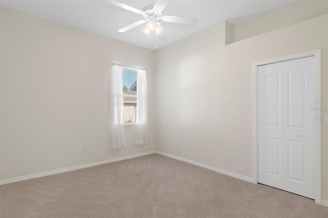 carpeted spare room featuring ceiling fan