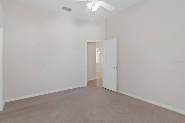 empty room with ceiling fan and light carpet