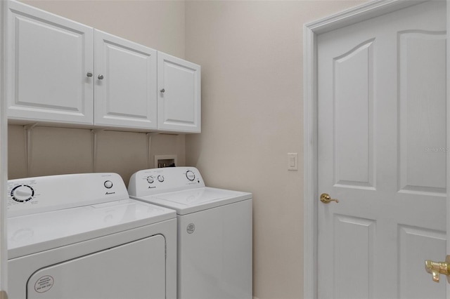 laundry room featuring cabinets and washer and clothes dryer