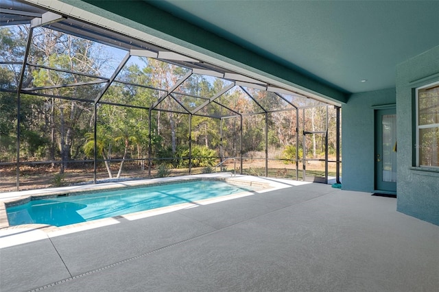 view of swimming pool with glass enclosure and a patio