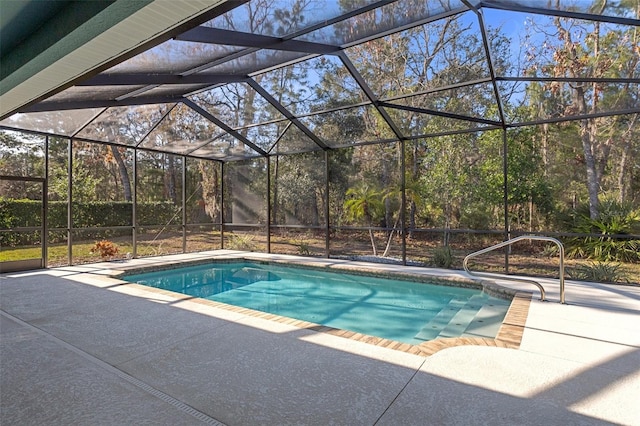 view of swimming pool featuring glass enclosure and a patio area