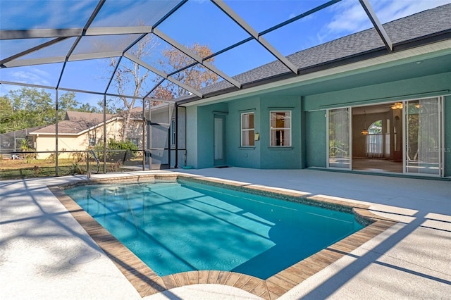 view of pool with a patio area and glass enclosure