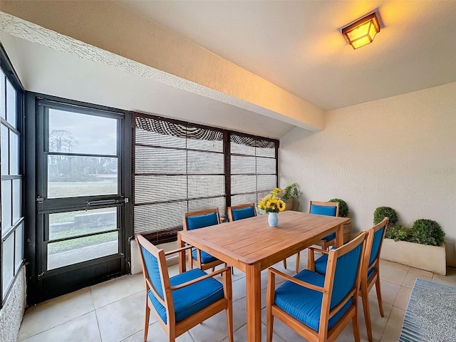 dining room featuring beam ceiling, light tile patterned floors, and a water view