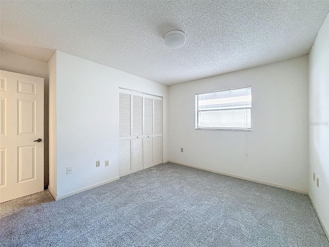 unfurnished bedroom with a textured ceiling, a closet, and carpet