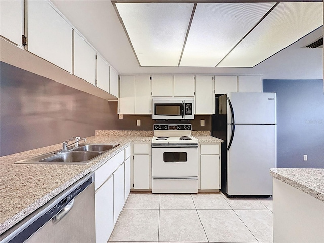 kitchen with stainless steel appliances, white cabinets, sink, and light tile patterned floors