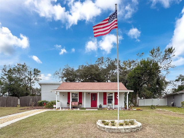 single story home featuring covered porch and a front yard