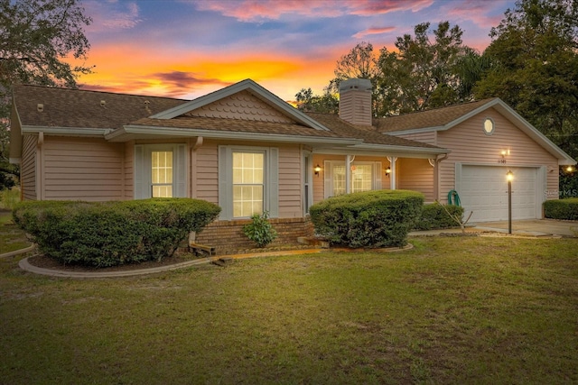 single story home with a garage and a lawn