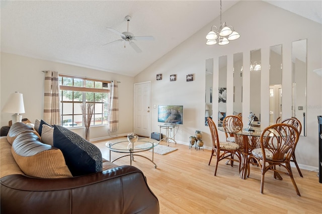 living room with hardwood / wood-style floors, high vaulted ceiling, and ceiling fan with notable chandelier