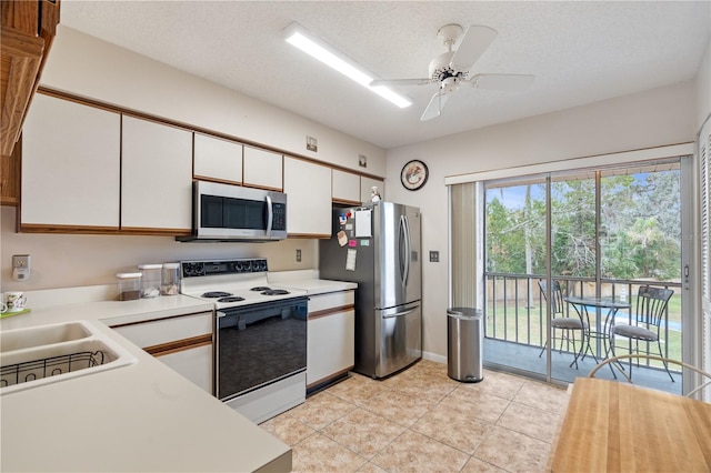 kitchen featuring sink, ceiling fan, a textured ceiling, white cabinetry, and stainless steel appliances