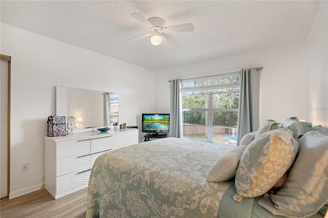 bedroom featuring ceiling fan, a textured ceiling, and light hardwood / wood-style flooring