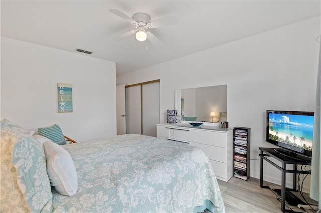 bedroom with ceiling fan, a closet, and light wood-type flooring