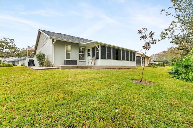 rear view of property with a lawn and a sunroom