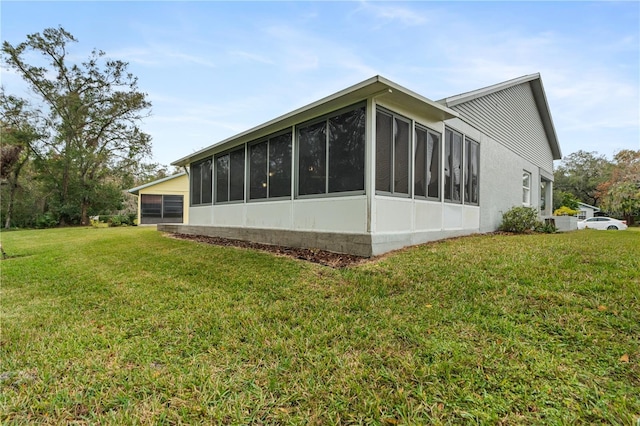 view of side of property featuring a lawn and a sunroom