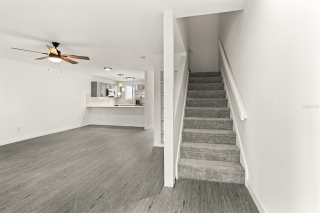 stairway featuring ceiling fan and hardwood / wood-style flooring