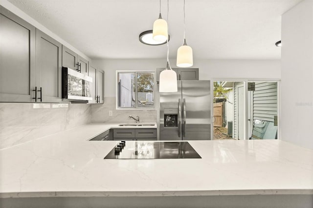 kitchen featuring pendant lighting, stainless steel appliances, a wealth of natural light, and gray cabinetry