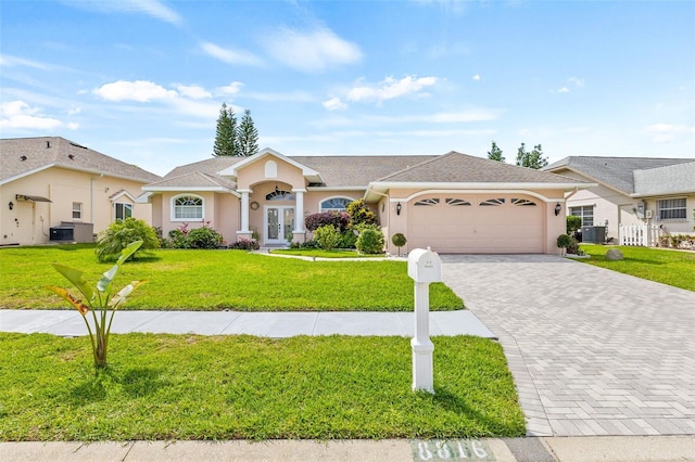 single story home with central air condition unit, a front lawn, and a garage