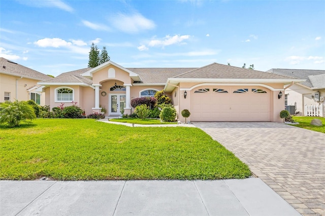 single story home with french doors, a front yard, and a garage