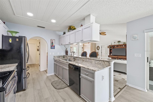 kitchen featuring appliances with stainless steel finishes, kitchen peninsula, ceiling fan, sink, and white cabinetry