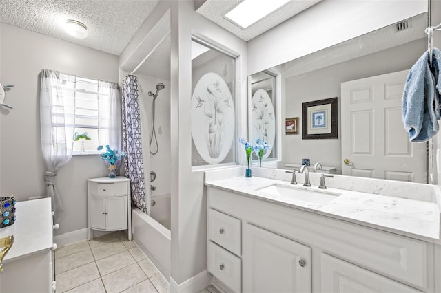 bathroom with tile patterned flooring, shower / bathtub combination with curtain, a textured ceiling, and vanity