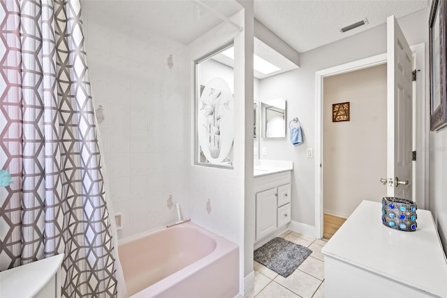 bathroom featuring tile patterned flooring, a textured ceiling, shower / tub combo with curtain, and vanity