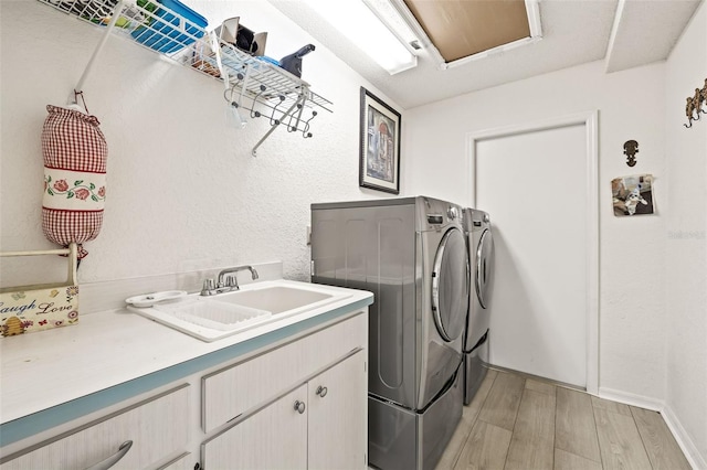 washroom with independent washer and dryer, cabinets, and sink